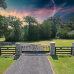 Multiple stone columns with custom metal lettering on a swing gate