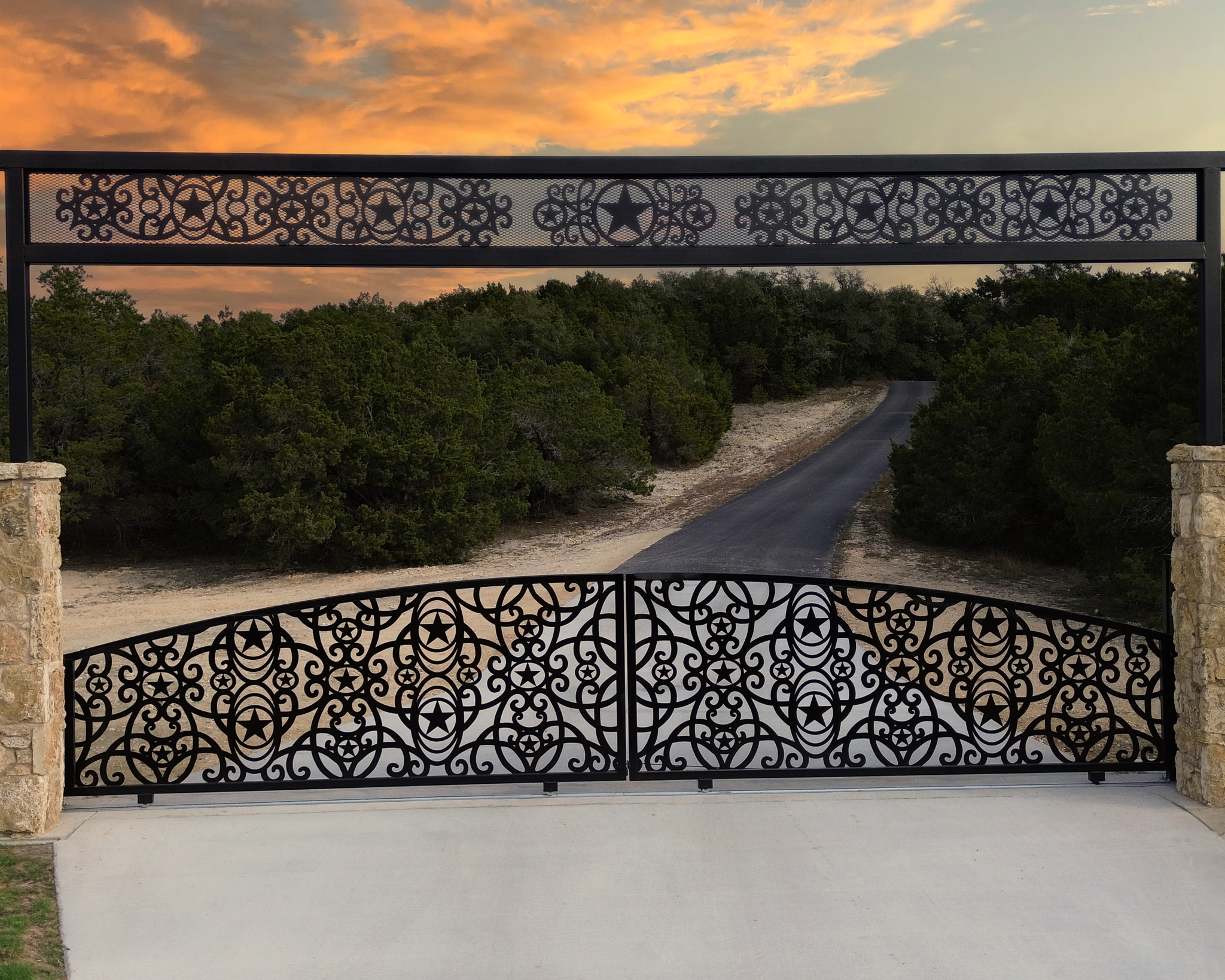 Texas sized entrance with two sliding gates with stars and circle/swirl art throughout gate and with same design in the overhead.
