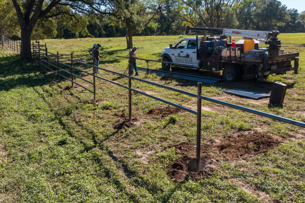 cutting and installing pipe fencing at an entrance