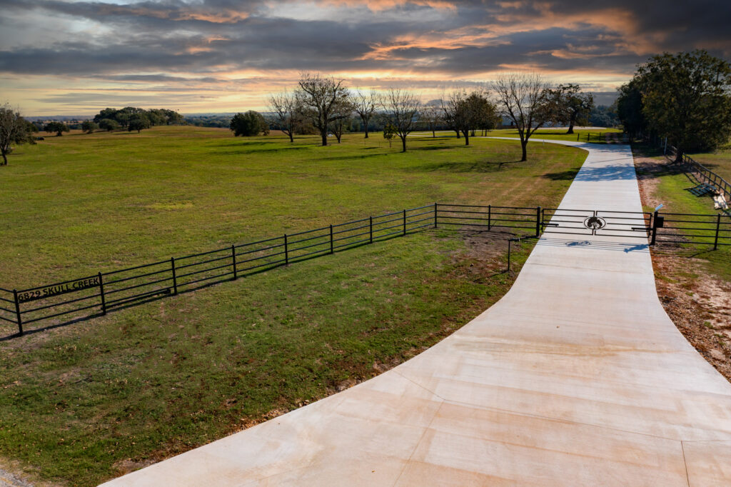 aerial view of farm entrance with pipe fencing surround the front entrance of farm with gate automation that is powered with solar.